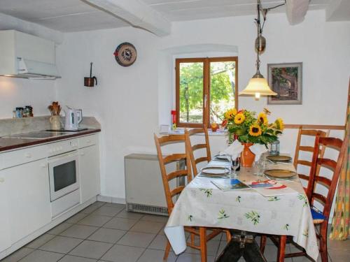 a kitchen with a table with a vase of flowers on it at Rustico Pult in Someo