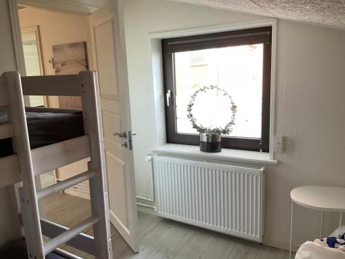 um quarto com uma janela com uma escada e uma escada em Strandhytten em Hvide Sande