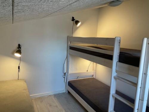 Cette chambre dispose de lits superposés et d'une échelle. dans l'établissement Strandhytten, à Hvide Sande