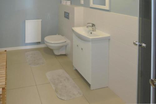 a white bathroom with a sink and a toilet at holiday home, Wiselka in Wisełka