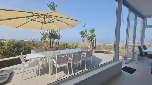 a patio with a table and chairs and an umbrella at Casa Villamaravilla II, Isla de El Hierro in Frontera