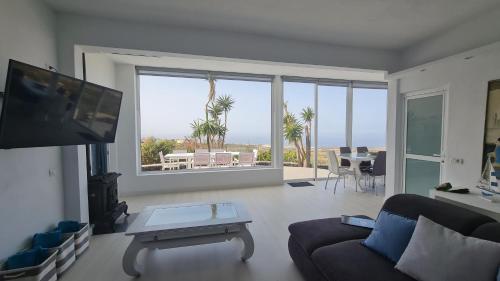 a living room with a couch and a flat screen tv at Casa Villamaravilla II, Isla de El Hierro in Frontera