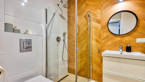 a bathroom with a shower and a sink and a mirror at Apartament Triventi 99 z Widokiem - 5D Apartamenty in Karpacz