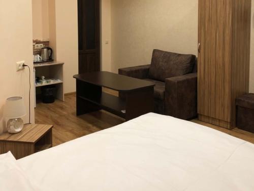 a room with a bed and a chair and a table at H Resort Hotel Vagharshapat Armenia in Vagharshapat
