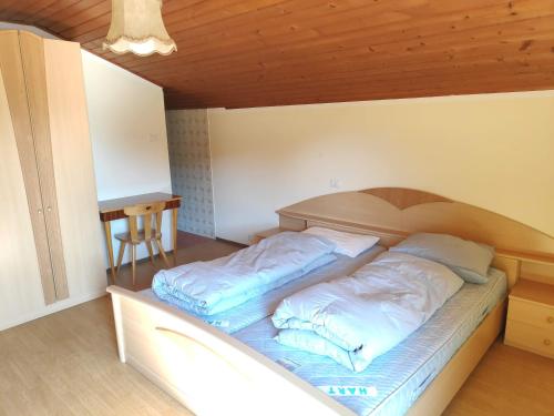 a bed in a room with blue pillows on it at Plonerhof - Ferienhaus Maria in Rodengo