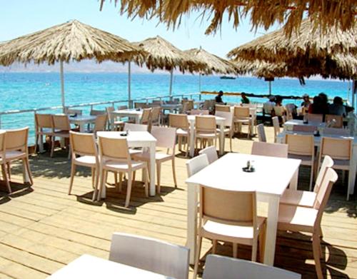 a restaurant on the beach with tables and chairs at Hotel Apartment Short Term Tel Aviv Bat Yam 5 in Bat Yam