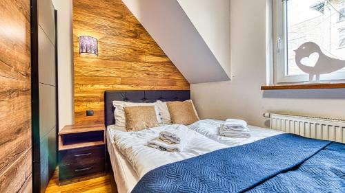 ein kleines Schlafzimmer mit einem Bett und einem Fenster in der Unterkunft Karpaczowy Klimat przy Deptaku - 5D Apartamenty in Karpacz