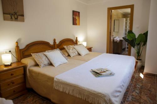 una camera da letto con un letto con un libro sopra di Casa Ramos a Navarrés