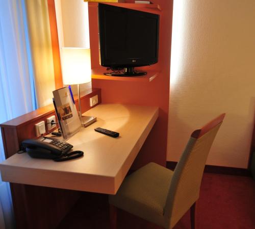 a room with a desk with a computer and a chair at Hotel Flandrischer Hof in Cologne