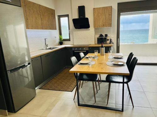 eine Küche mit einem Tisch, Stühlen und Meerblick in der Unterkunft Zonapartments B sea view- city center in Chania