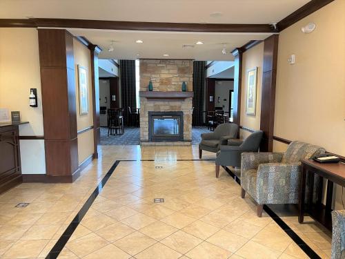 a lobby with chairs and a fireplace in a building at Staybridge Suites Milwaukee West-Oconomowoc by IHG in Oconomowoc