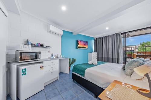 a hotel room with a bed and a tv at Airlie Sun & Sand Accommodation Studio #1 in Airlie Beach