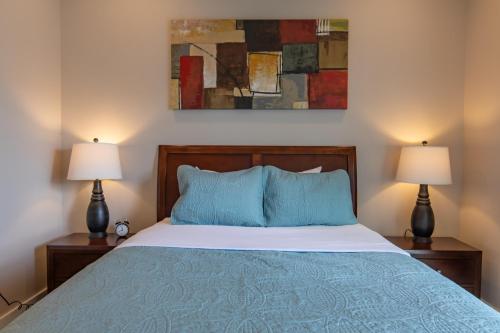 a bedroom with a bed with blue pillows and two lamps at Rockaway beach vibes,Waterfront Oceanfront Rockaway Beach House near Downtown,WIFI, Washer Dryer in Rockaway Beach