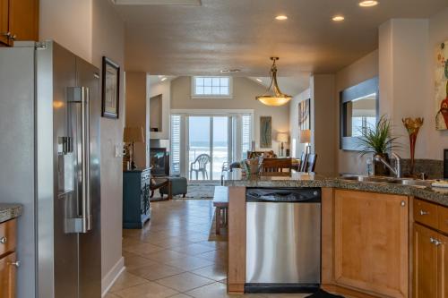 a kitchen with stainless steel appliances and a living room at Rockaway beach vibes,Waterfront Oceanfront Rockaway Beach House near Downtown,WIFI, Washer Dryer in Rockaway Beach