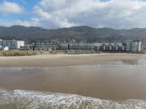 a view of a beach with buildings in the background at Rockaway beach vibes,Waterfront Oceanfront Rockaway Beach House near Downtown,WIFI, Washer Dryer in Rockaway Beach