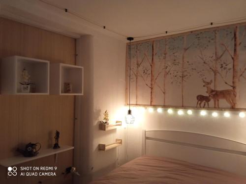 a bedroom with a bed with lights on the wall at La casita de mi abuela in Santo Domingo de la Calzada