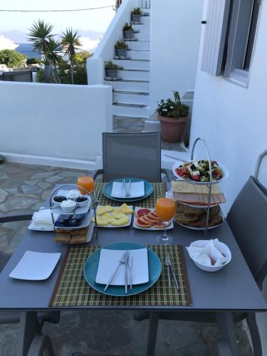 a picnic table with plates of food on a balcony at Melangel in Mýkonos City