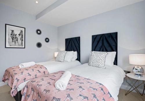 two beds in a room with white walls at Southern View By My Getaways in Brighton & Hove
