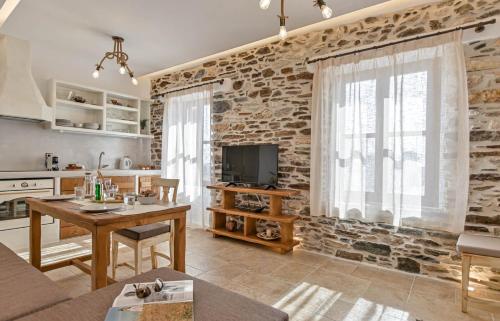 a kitchen and living room with a stone wall at Memorias Sangri Naxos in Áno Sangríon