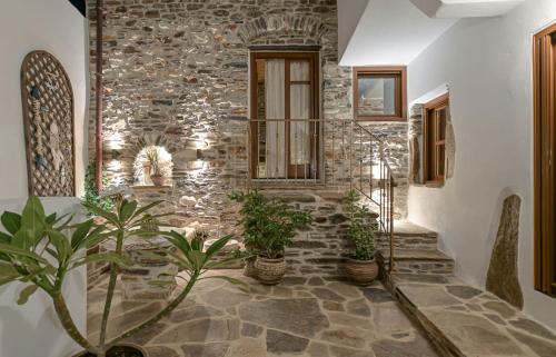 a stone wall with potted plants in a hallway at Memorias Sangri Naxos in Áno Sangríon