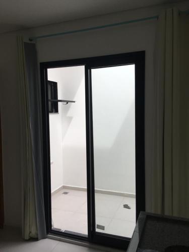 una puerta corredera de cristal en una habitación con baño en H34 Hotel, en Guarulhos