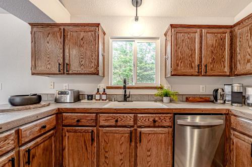 a kitchen with wooden cabinets and a sink and a window at Hedge Rose House in McKinleyville