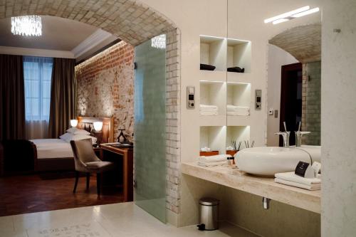 a bathroom with a sink and a bedroom with a bed at Hotel Alter in Lublin