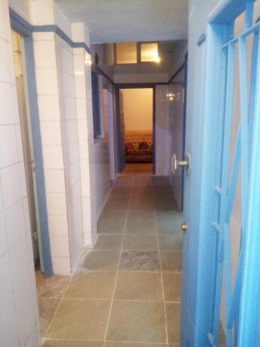 a hallway with a blue door and a tile floor at CIT Y Khadra in Tunis