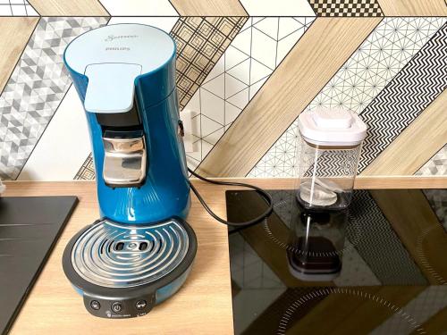 une cafetière bleue assise au-dessus d'une table dans l'établissement Appartement vue sur les étoiles, à Charleville-Mézières