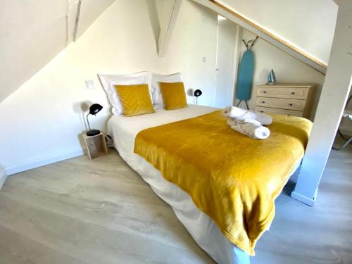 une chambre avec un grand lit avec une couverture jaune dans l'établissement Appartement vue sur les étoiles, à Charleville-Mézières