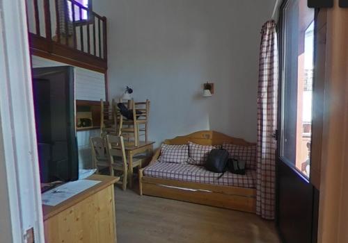 a living room with a couch and a television at Tignes rond point des pistes vue panoramique au soleil in Tignes