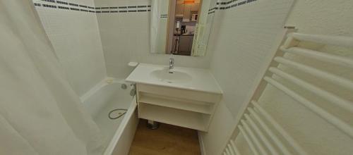 a white bathroom with a sink and a bath tub at Tignes rond point des pistes vue panoramique au soleil in Tignes