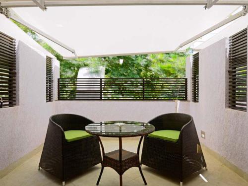 a patio with a glass table and two chairs at Hotel Grande 51 in Navi Mumbai