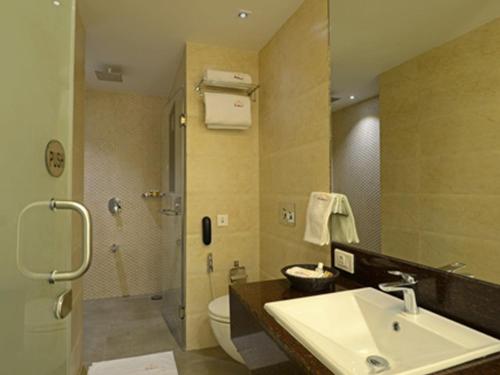 a bathroom with a sink and a toilet and a shower at Hotel Grande 51 in Navi Mumbai