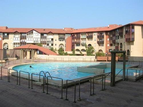 une grande piscine devant certains bâtiments dans l'établissement Appartement HOSSEGOR plage SUD Classé 3 étoiles, à Soorts-Hossegor
