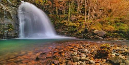 a waterfall in the middle of a body of water at A Casiña do Patio in Quiroga
