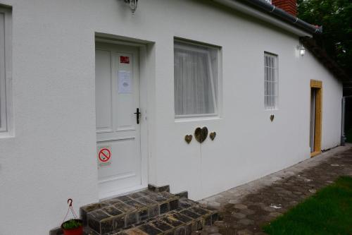 a white house with a door and a window at Dve kuce pored jezera in Palić