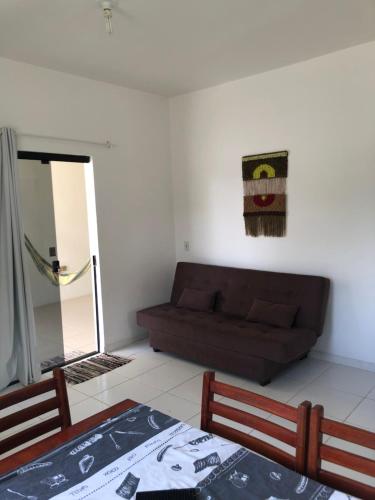 un soggiorno con divano e tavolo di Apartamentos Praia do Sonho a Palhoça