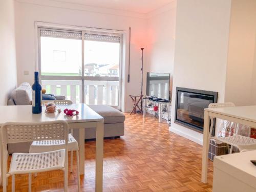 una sala de estar con una mesa y una chimenea en Beach Lovers Surf House - Aveiro - Praia da Barra, en Praia da Barra