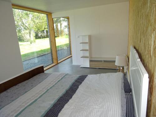 une chambre avec un lit et une grande fenêtre dans l'établissement Holiday Home on Goëlo Coast with Sea Views, à Les Valoyens