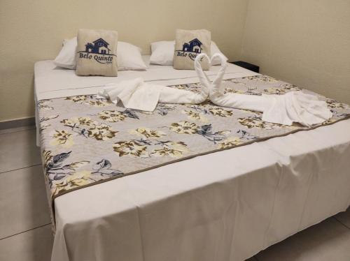 two beds with white sheets and towels on them at Belo quinto Styles pousada in Brotas