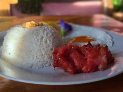 Camp Paraiso Resort في Salabusob: طبق من الرز واللحوم مع الصلصة عليه