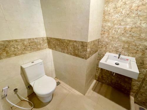 a bathroom with a toilet and a sink at Apartemen MATARAM CITY YUDHISTIRA TOWER YOGYAKARTA in Kejayan