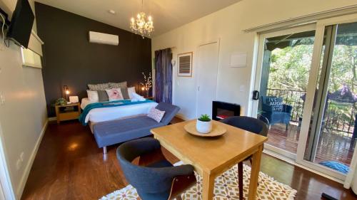 Phillip Island Nature Resort Villas في كاوز: غرفة نوم بسرير وطاولة وكراسي