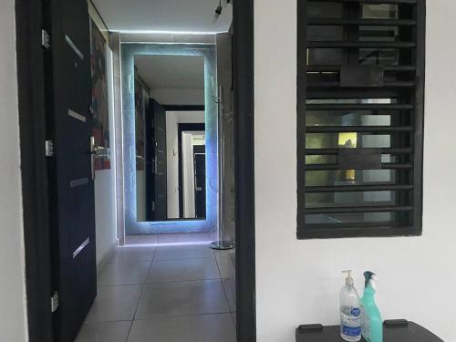 a bathroom with a mirror and a hallway with a door at Alojamiento completo, con una excelente ubicación in Guadalajara