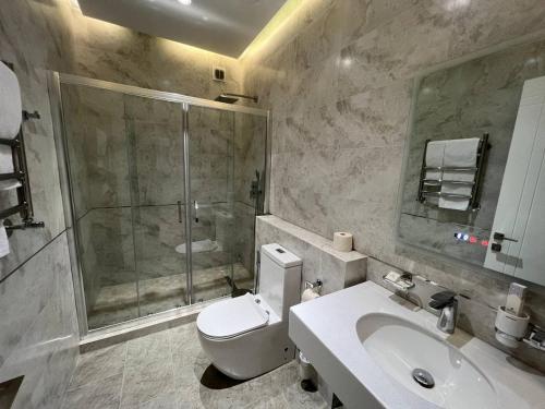 y baño con ducha, aseo y lavamanos. en PANA HOTEL, en Nukus
