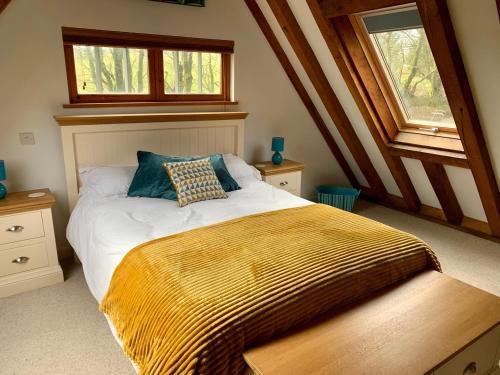 a bedroom with a bed with a blanket on it at Bybrook Lodge in Camelford