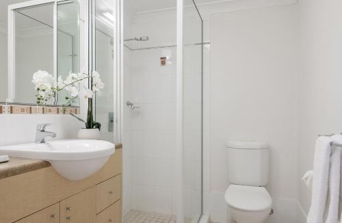 a bathroom with a toilet and a sink and a shower at Central Plaza Port Douglas in Port Douglas