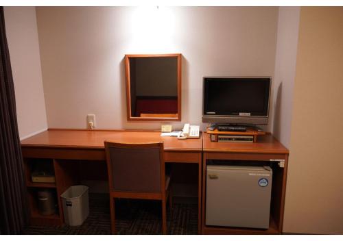 a desk with a computer and a television on it at Hotel Hachiman in Hachiman