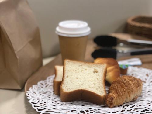a plate with two slices of bread and a cup of coffee at Business Hotel Urbanty Nishikujo in Osaka